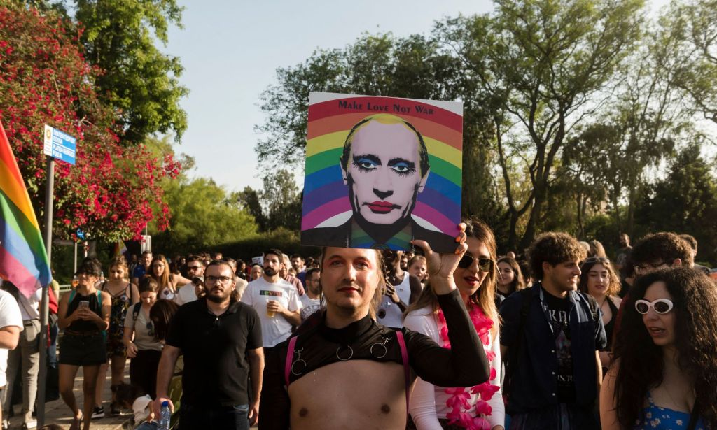 A person holds up a picture of Russia's president Vladimir Putin with the rainbow colours of the LGBTQ+ pride flag during a protest in favour of the trans and queer communities