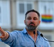 far-right party Vox leader Santiago Abascal holds his hand up during a political rally in Spain ahead of the general election as an LGBTQ+ flag can be seen in the background