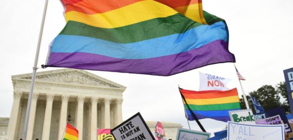 A LGBT pride flag waves in front of the Supreme Court