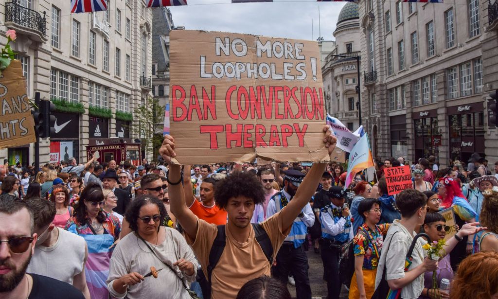 An activist holds up a sign reading 'no more loopholes ban conversion therapy' during the London Trans+ Pride march where advocates call for trans and LGBTQ+ people to be safe from persecution