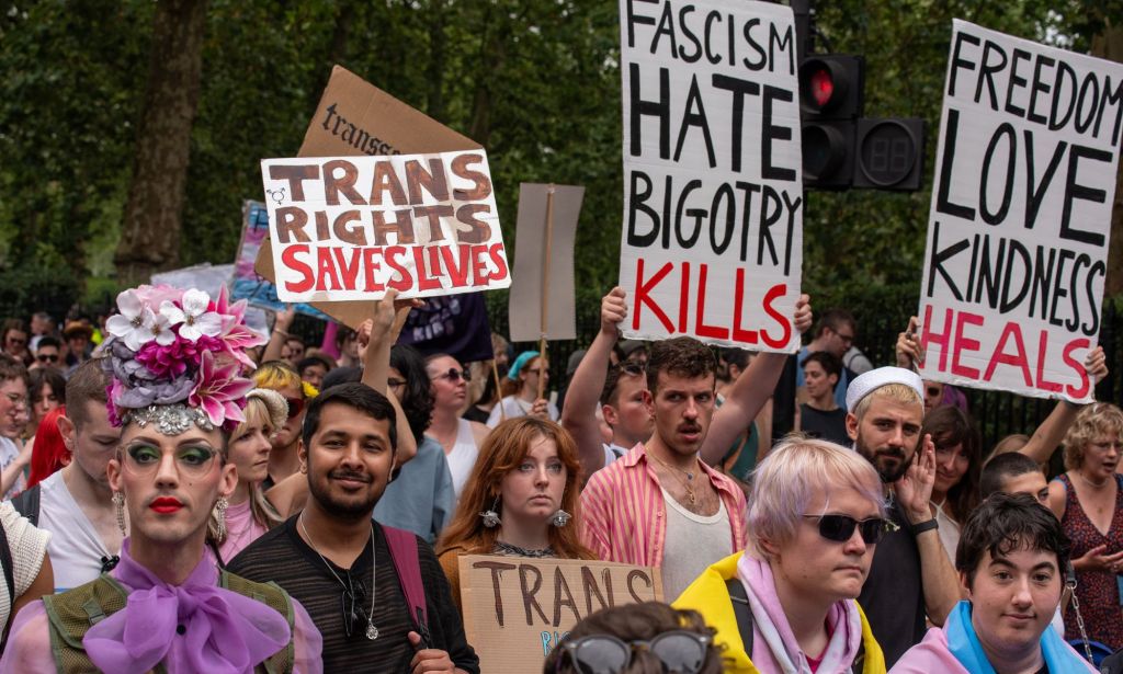 An activist holds up a sign reading 'trans rights saves lives' while others hold up signs denouncing fascism during the London Trans+ Pride march where advocates call for trans and LGBTQ+ people to be safe from persecution