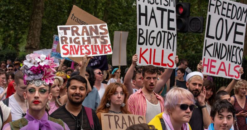 An activist holds up a sign reading 'trans rights saves lives' while others hold up signs denouncing fascism during the London Trans+ Pride march where advocates call for trans and LGBTQ+ people to be safe from persecution