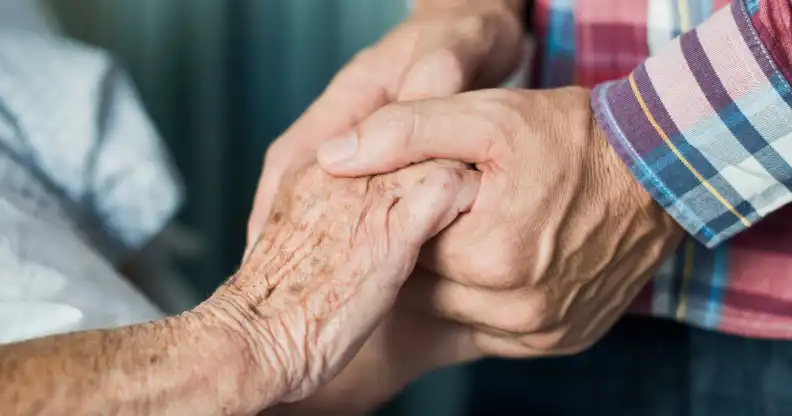 Gay couple hold hands in care home