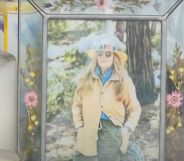A picture of California store owner Laura Ann Carleton in a frame with flowers set up during a memorial after Carleton was fatally shot by an unidentified man who made "disparaging remarks" about an LGBTQ+ Pride flag outside her store