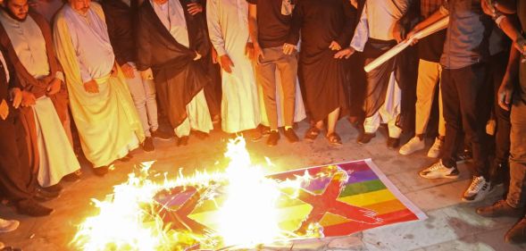 Homophobic protestors in Iraq burn two Pride flags with X's drawn on them