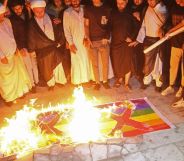 Homophobic protestors in Iraq burn two Pride flags with X's drawn on them