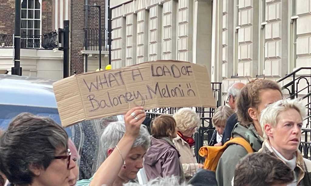 "What a load of baloney, Meloni" placard.  (PinkNews) 