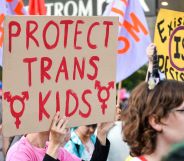 Protester holds up a sign reading "protect trans kids"