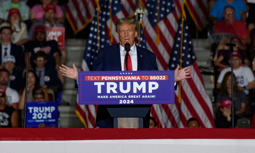 Donald Trump wears a white shirt, red tie and dark jacket as he speaks at a campaign event
