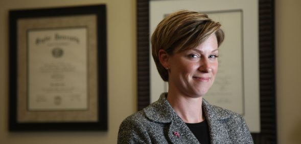 Former Republican Texas state representative Sarah Davis wears a black shirt and dark jacket as she smiles at the camera