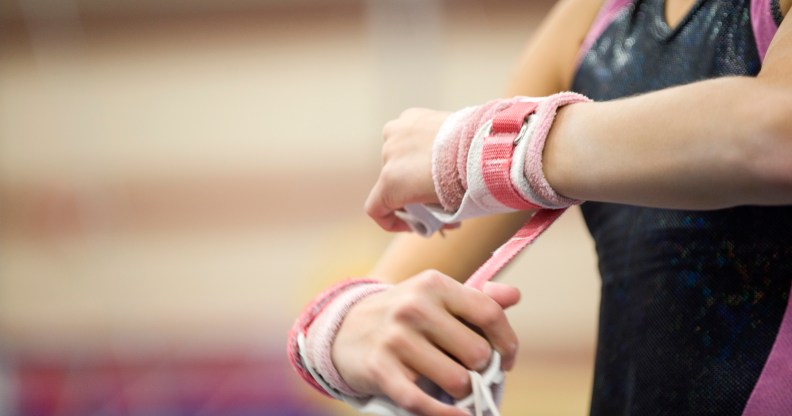 Female gymnast wrapping wrists in preparation, cropped