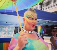 Florida drag queen Michael "Erika Rose" Travis holds up a rainbow umbrella and wears rainbow coloured clothing as she attends an LGBTQ+ event