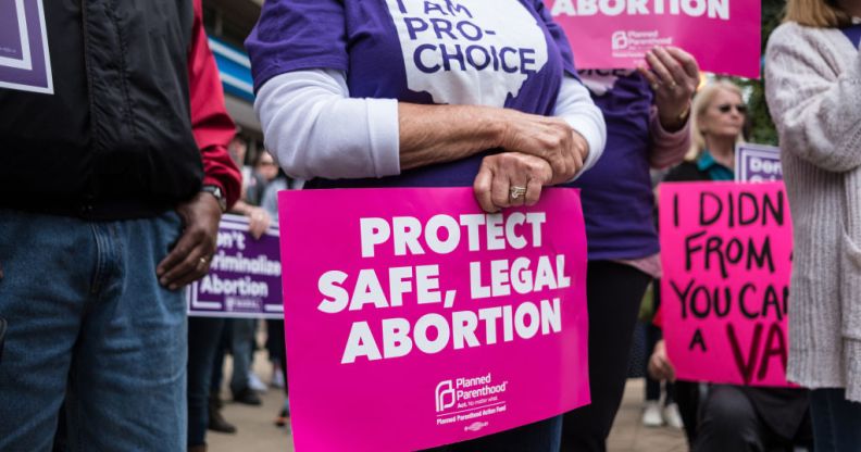 An activist seen holding a placard that says protect safe, legal abortion