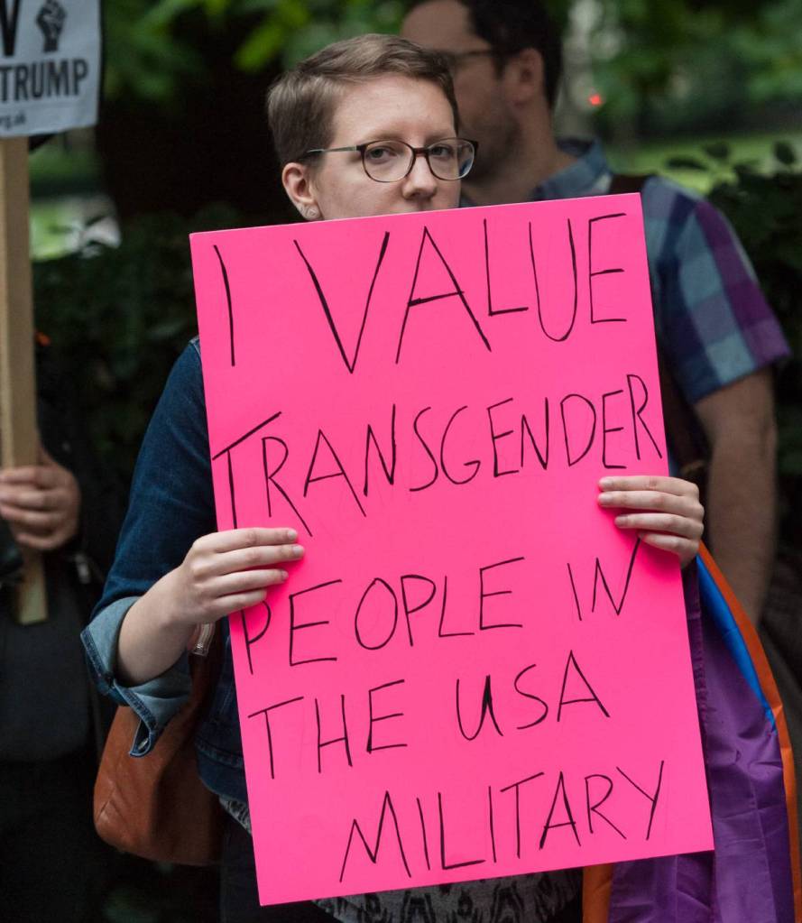 A person holds up a sign reading 'I value transgender people in the USA military' during a protest