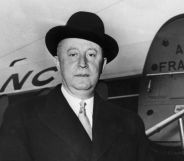 A black and white photo of fashion designer Christian Dior stood in front of an Air France plane.