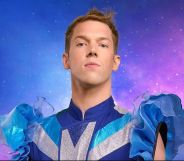 Drag Race Belgique judge Mustii in his promotional photo, wearing a blue and silver top with puffy blue sleeves.