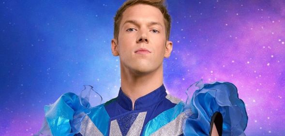 Drag Race Belgique judge Mustii in his promotional photo, wearing a blue and silver top with puffy blue sleeves.