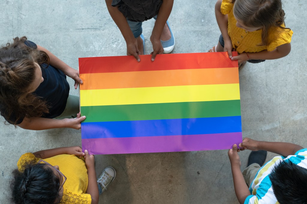Students hold LGBTQ+ Pride flag