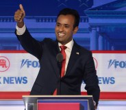2024 Presidential candidate Vivek Ramaswamy stands behind a debate podium making a thumb's up sign