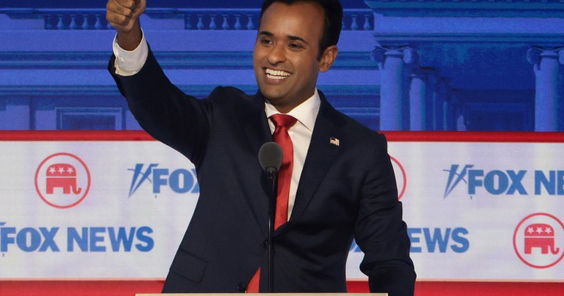 2024 Presidential candidate Vivek Ramaswamy stands behind a debate podium making a thumb's up sign