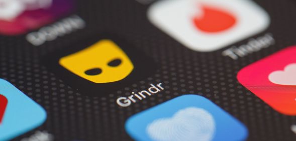 Stock image of the Grindr app logo on a phone