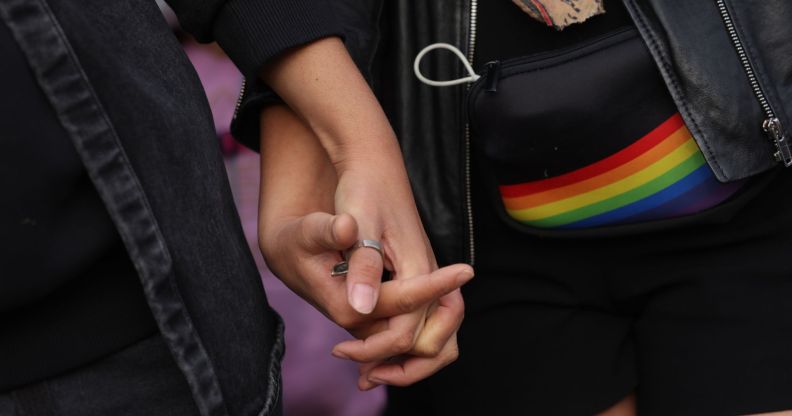 An unnamed same-sex couple holding hands.