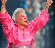 Pink, arms raised, sings into an ear-piece microphone.