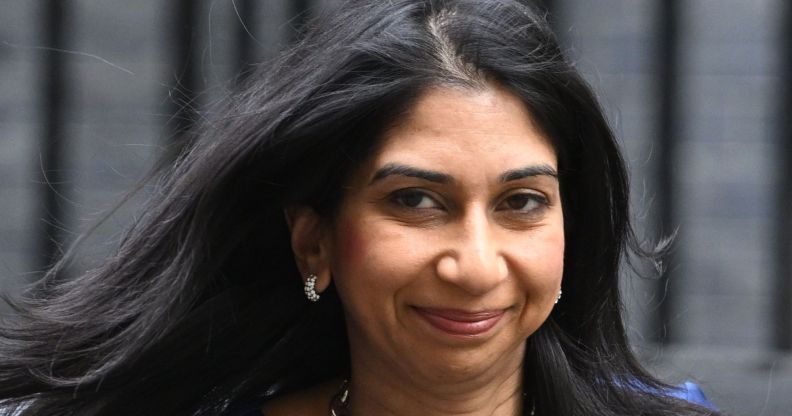 Suella Braverman, smiling as she walks down a walkway.