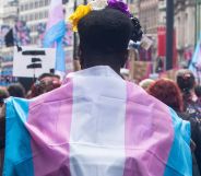 A protestor wearing a trans flag during a Pride event.