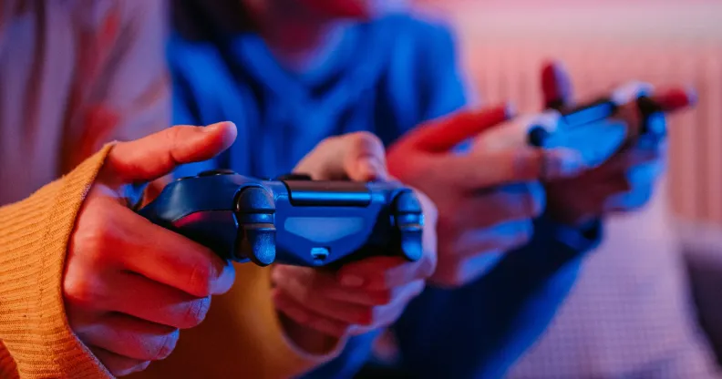 Two people play video games using game controllers.