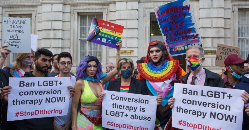 People hold up signs reading 'Ban LGBT+ conversion therapy NOW!' and 'conversion therapy is LGBT+ abuse' as they call on the Tory government to take action