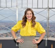 Drew Barrymore pictured wearing a yellow blouse and a grey skirt at an event in New York City.
