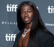 Lil Nas X wears long black hair and a black jacket at the premiere of his documentary, which was delayed because of a bomb threat
