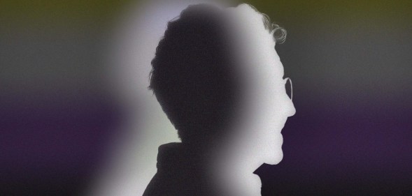 The image shows a silhouette of a person standing in side-profile against the non-binary flag colours.