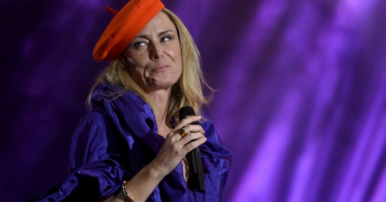 Singer-songwriter Róisín Murphy holds a microphone as she performs onstage in a purple outfit and with a red hat