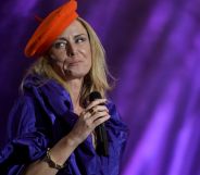 Singer-songwriter Róisín Murphy holds a microphone as she performs onstage in a purple outfit and with a red hat