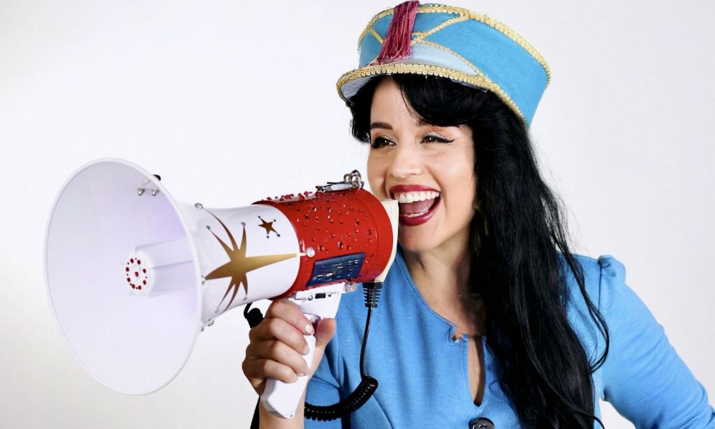 Kerry Lynn, founder of Texas drag business EXTRAGRAMS, wears a blue outfit as she screams into a megaphone. THe business was start of a lawsuit fighting the state's drag ban legislation