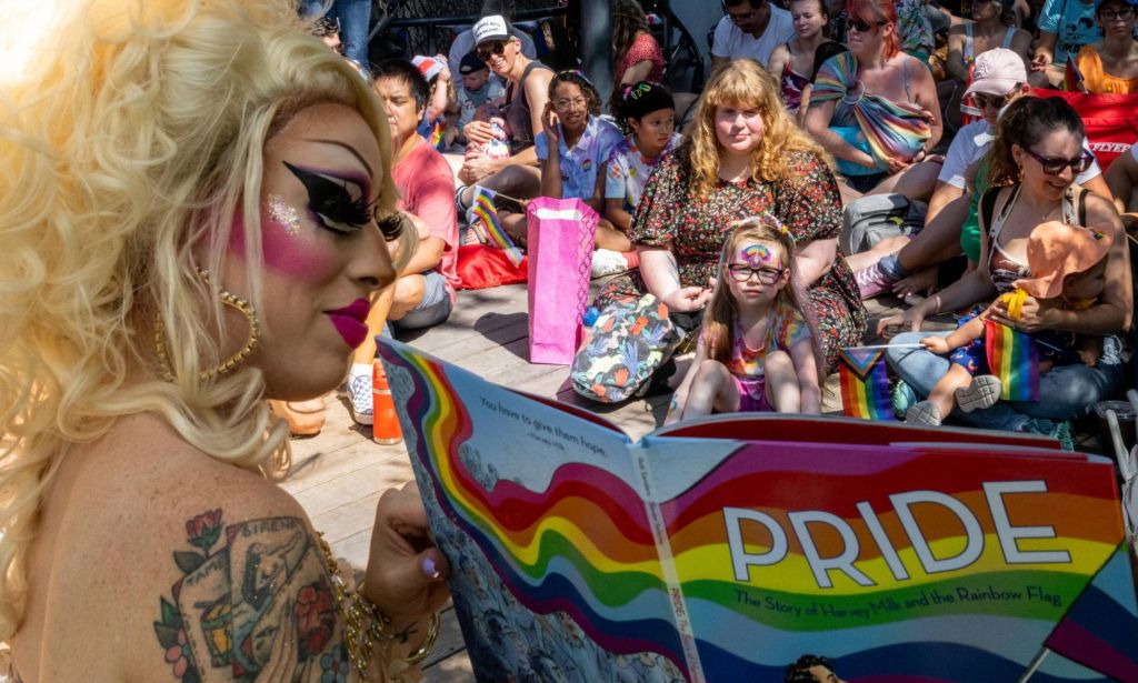 Texas drag queen Brigitte Bandit, who brought a legal case against the state's drag ban legislation, wears a blonde wig and sparkly outfit as she reads from a book to a crowd of people