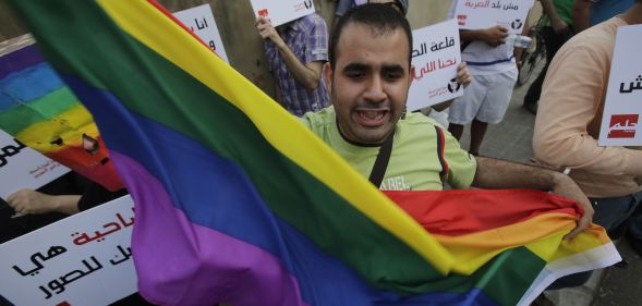 A protestor waves a Pride flag during an anti-homophobia rally in Beirut on 30 April 2013