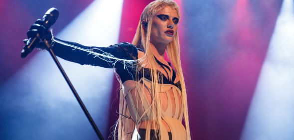 Drag race star Bimini Bon Boulash holds a microphone on stage
