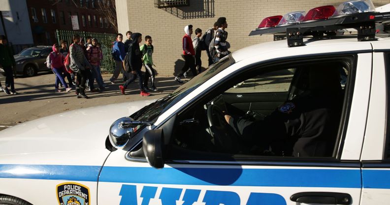 An NYPD police car next to a group of children heading to school.
