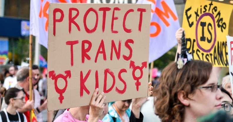 A protester holding a sign that reads 'protect trans kids'