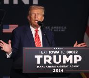 Donald Trump stands behind a podium reading "Trump"