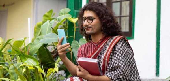 Stock photo of a transgender non-binary person using a mobile phone in an educational institute in India (Getty)