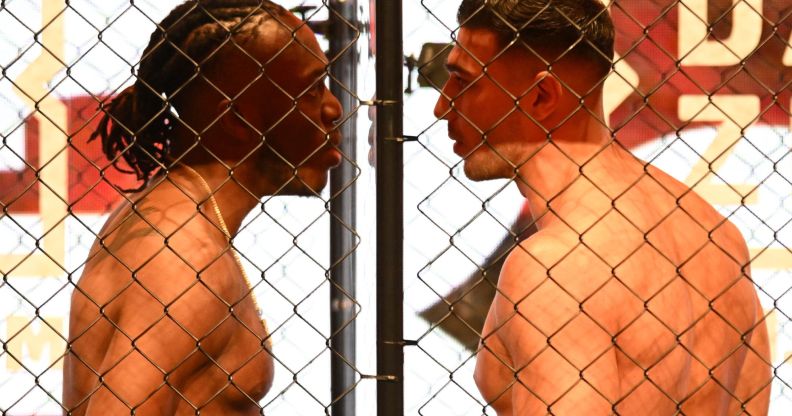 KSI and Tommy Fury stand face to face between glass and inside a cage.