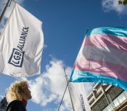 An LGB Alliance waves next to a trans flag.