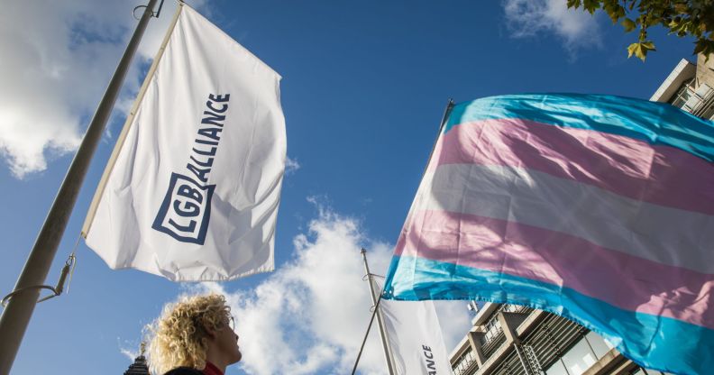 An activist holds a transgender pride flag at a protest by Transgender Action Block and supporters outside the first annual conference of the LGB Alliance at the Queen Elizabeth II Centre on 21st October 2021 in London, United Kingdom.
