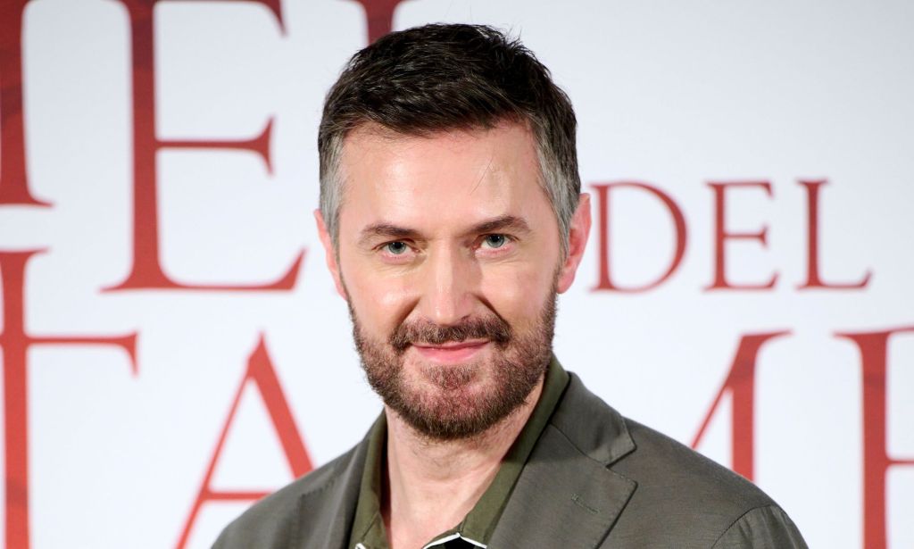 Richard Armitage in a green shirt on the red carpet looking at the camera.
