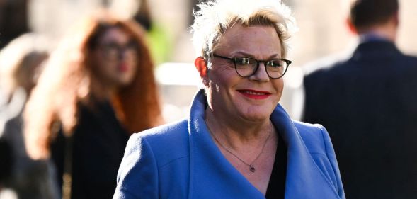 Comedian Suzy Eddie Izzard wearing a blue coat and red lipstick