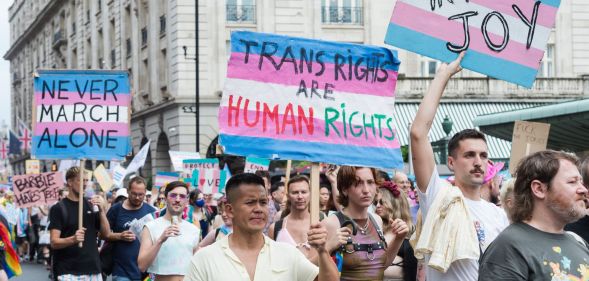 Protesters carry placards reading "trans rights are human rights"